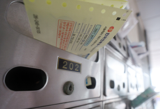 윤석열 대통령이 전자결재로 전기요금과 텔레비전 방송수신료(KBS·EBS 방송 수신료) 징수를 분리하기 위한 방송법 시행령 일부개정안을 재가한 11일 오후 서울 마포구의 한 다세대주택 우편함에 전기요금 청구서가 꽂혀 있다. 연합뉴스